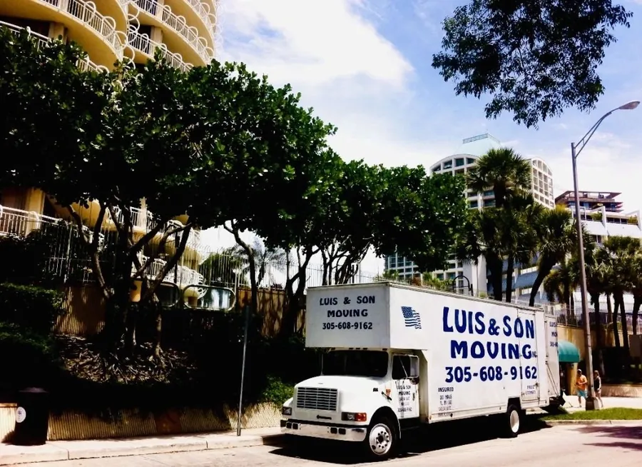 Luis & Son Moving truck parked by Miami high-rise condos and palm trees