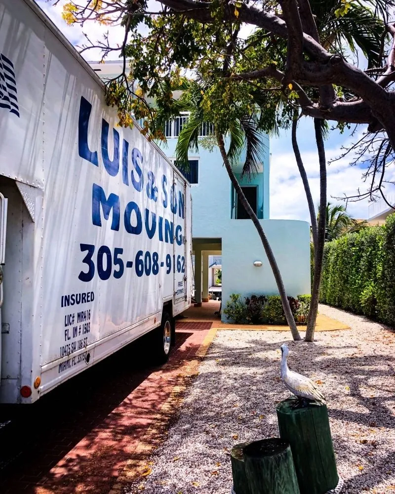 Side of the Luis & Son Moving truck showing its insured and license lettering